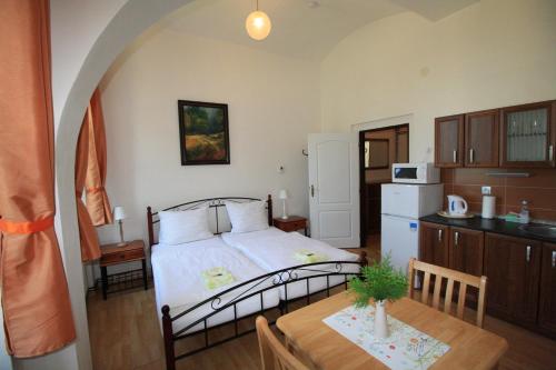 ein Schlafzimmer mit einem Bett und einem Tisch sowie eine Küche in der Unterkunft Bynovecký Zámeček in Bynovec