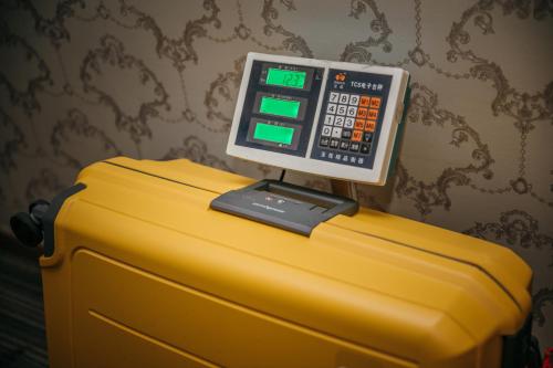 a computer on top of a yellow suitcase at Muzik Hotel - Ximending Xining Branch in Taipei