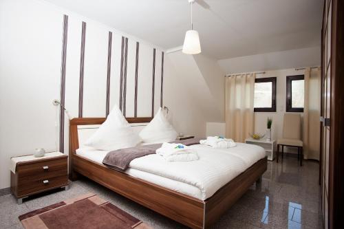 a bedroom with a bed with white sheets and pillows at Ferienwohnung Cella in Zell an der Mosel