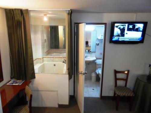 uma casa de banho com banheira e uma televisão na parede em Intiotel Chiclayo em Chiclayo