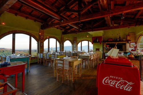 a cocacola restaurant with tables and chairs and windows at Agriturismo Il Sapore Della Luna in Monteprandone