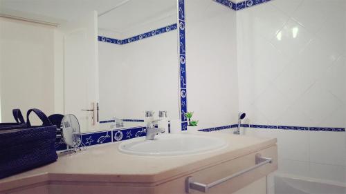 ラゴスにあるCasamarの- 白いシンクと青と白のタイルを用いたバスルーム