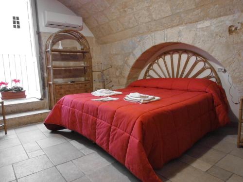 a bedroom with a bed with a red blanket at B&B Borgo San Martino in Monopoli