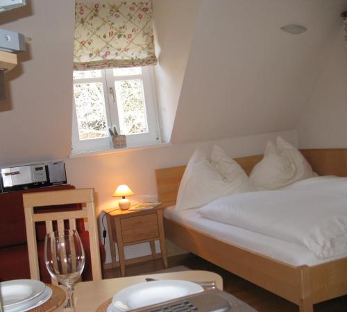 Schlafzimmer mit einem Bett und einem Tisch mit einem Glas Wein in der Unterkunft Winzerhaus Friedrich in Kaindorf