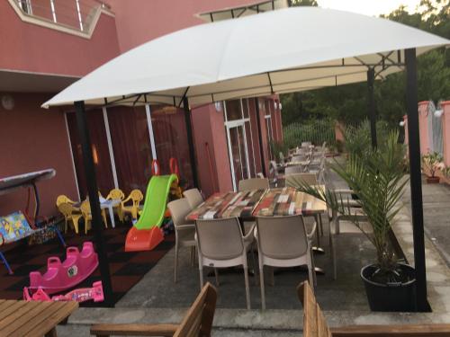 a table and chairs under an umbrella on a patio at Свети Кирил Лозенец in Lozenets