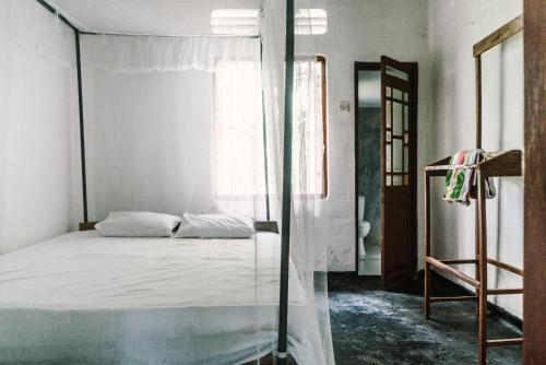 a bedroom with a bed and a glass wall at New Sam Tourist Inn in Weligama