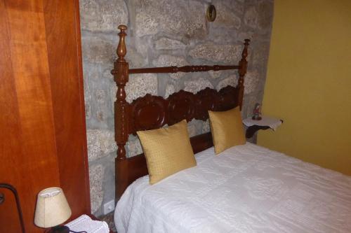 a bed with a wooden headboard in a bedroom at Casa do Rio in Moita