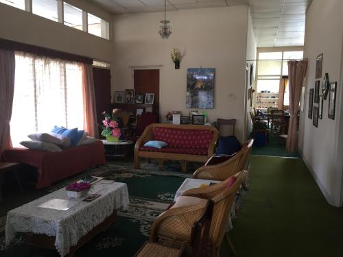 uma sala de estar com um sofá, uma mesa e cadeiras em Astani Family Home em Bukittinggi