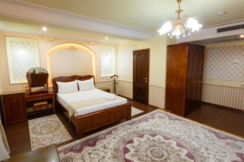a bedroom with a bed and a desk and a chair at Salut Hotel Almaty in Almaty