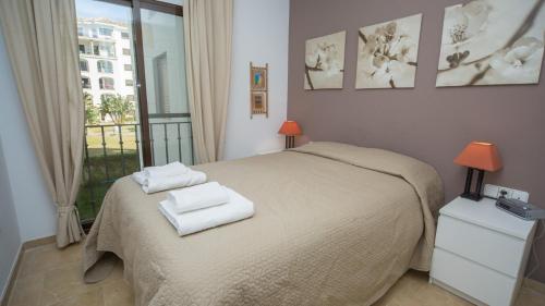 マニルバにあるMarina de la Duquesa 213のベッドルーム1室(ベッド1台、タオル2枚付)