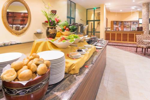 linia bufetowa z talerzami i miskami z jedzeniem w obiekcie Gold Crest Hotel - Arusha w mieście Arusza