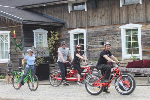 a group of people on bikes in front of a cabin at Elves Village Hotel in Levi