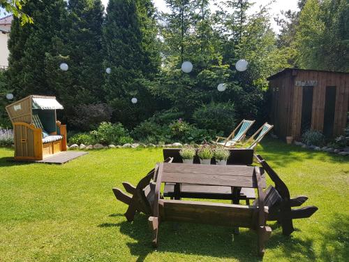 a wooden picnic table in a yard with balloons in the air at 4 STRONY ŚWIATA Pokoje i Apartamenty in Dźwirzyno