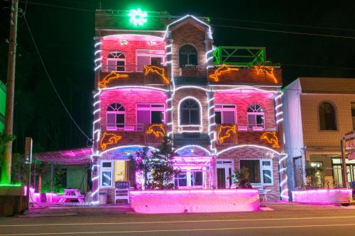 a pink house with lights on the side of it at Ez Bay Homestay in Chenggong