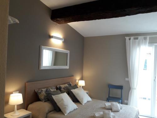 a bedroom with a bed with two lamps and a window at Santa Marta Rooms - Vernazza in Vernazza
