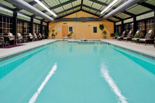 - une piscine d'eau bleue dans un bâtiment dans l'établissement Fort Magruder Historic Williamsburg, Trademark by Wyndham, à Williamsburg