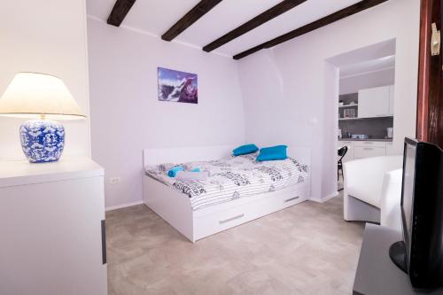 a white bedroom with a bed and a desk at Apartments Bella Tara in Piran