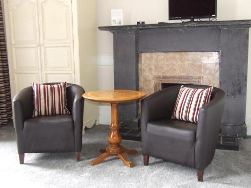 傑德堡的住宿－皇家酒店，壁炉前的两把椅子和一张桌子