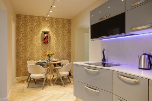 a kitchen and dining room with a table and chairs at Dönhoff Residence in Pärnu