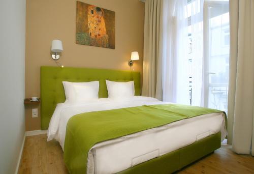 uma cama verde e branca num quarto com uma janela em AS Smart Apartment Old Town Krakow em Cracóvia