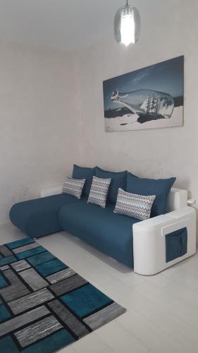 sala de estar con sofá azul y TV en Apartament Luk Twin Loft, en Mamaia