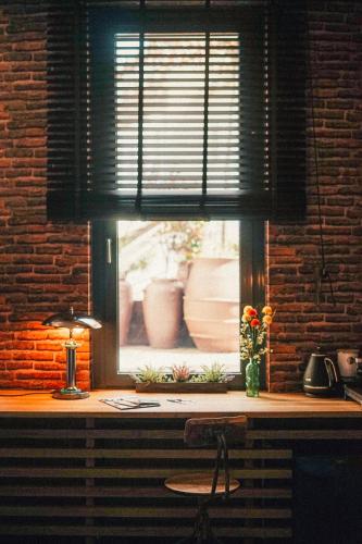 a window with a desk with a lamp and flowers at 36 Phô Cô Hotel & Suites in Weimar