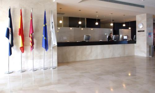 a row of flags in a lobby with a woman at Senator Águilas in Águilas