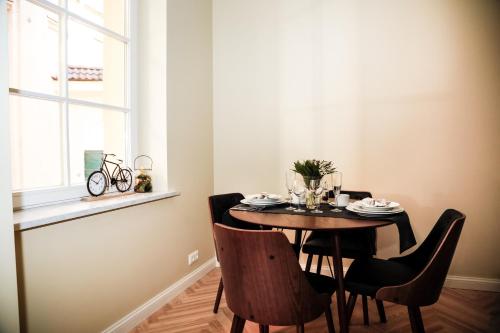 a dining room with a table and chairs and a window at Dönhoff Residence in Pärnu