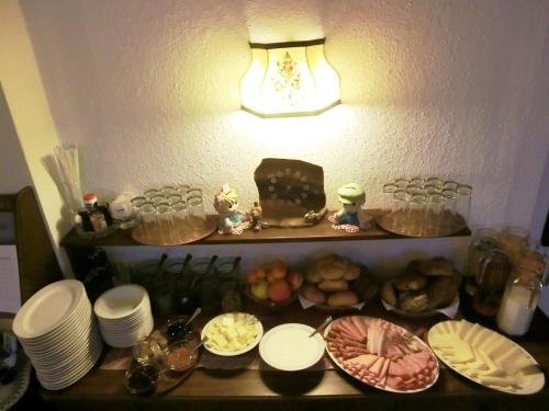 a table with plates and food on top of it at Hotel garni Landhaus Bürtlmair in Hinterstoder