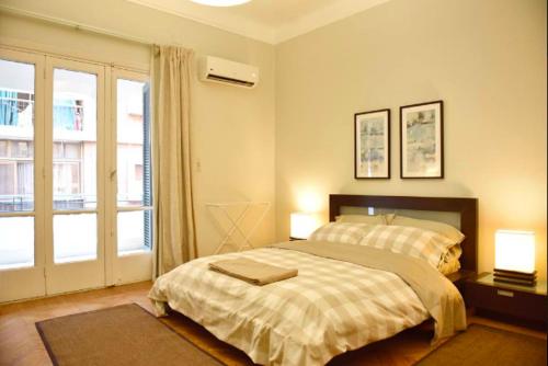 1 dormitorio con 1 cama, 2 lámparas y ventana en Beautiful, Newly Renovated Flat in Zamalek, Cairo, en El Cairo