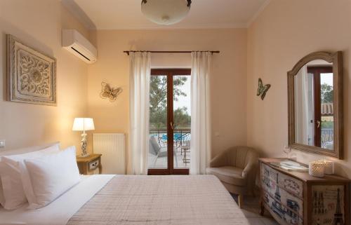 a bedroom with a bed and a chair and a window at Aneli Luxury Villas-Villa Anastasia in Ayios Kirikos