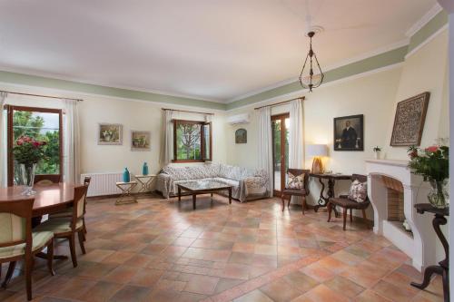 a living room with a couch and a table at Aneli Luxury Villas-Villa Anastasia in Ayios Kirikos