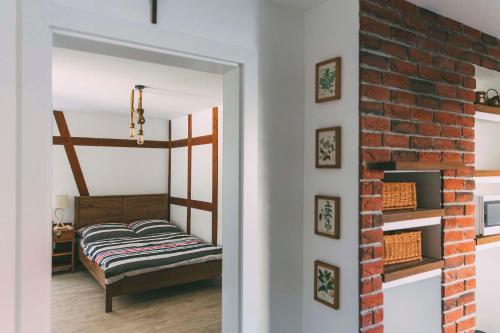 ウェバにあるApartament Stara Jabłońのレンガの壁、ベッド付きのベッドルーム1室