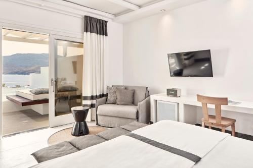 カロ・リヴァディにあるArchipelagos Hotel - Small Luxury Hotels of the Worldのベッドルーム1室(ベッド1台付)、リビングルームが備わります。