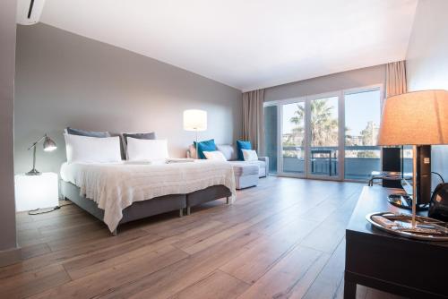Un dormitorio con una cama y una sala de estar con un sofá. en Cascais-Estoril BEACHFRONT Apartments, en Estoril
