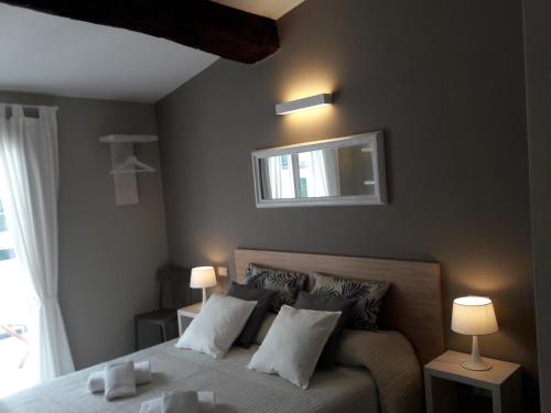 a bedroom with a bed with two lamps and a window at Santa Marta Rooms - Vernazza in Vernazza
