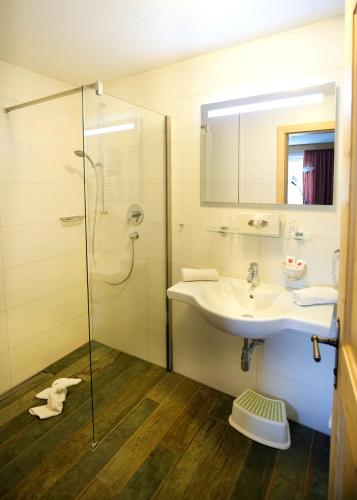 a bathroom with a sink and a shower at Alpenstern rooms & suites in Lermoos