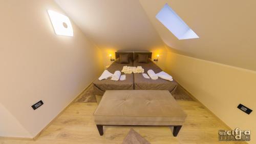 a attic bedroom with two beds and a window at Vila Alexandar 15 in Bački Petrovac