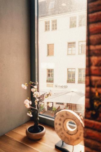 a window with a flower vase and a view of a building at 36 Phô Cô Hotel & Suites in Weimar
