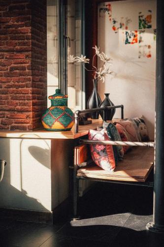 a shelf with vases on it with a table with a shelfngth at 36 Phô Cô Hotel & Suites in Weimar