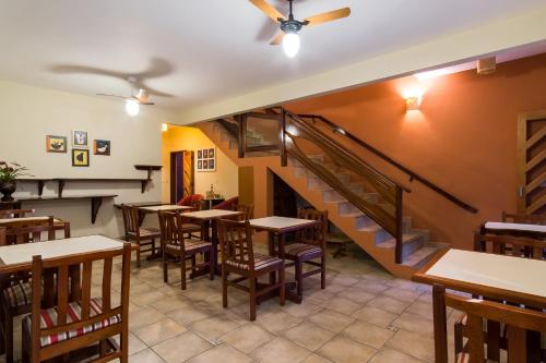 ein Restaurant mit Tischen und Stühlen und einer Treppe in der Unterkunft Pousada Mar Azul in Ubatuba