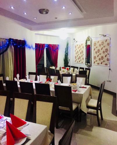 a dining room with tables and chairs and red curtains at Villa Bella Boutique Hotel in Kavadarci