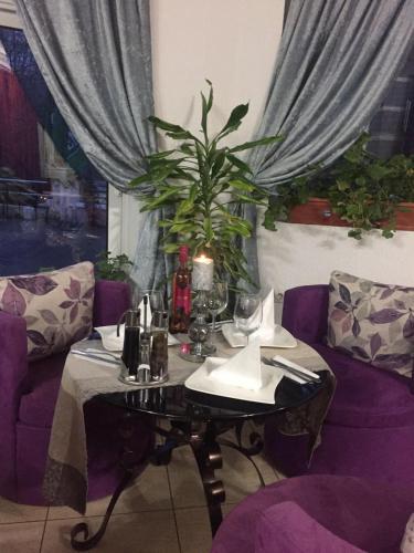 a table with a purple couch and a table with a plant at Villa Bella Boutique Hotel in Kavadarci