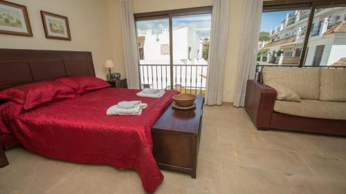 una camera da letto con un letto rosso e asciugamani di Marina Real 534 a Manilva