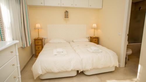 マニルバにあるMykonos Playa 14のベッドルーム1室(白いベッド1台、タオル2枚付)