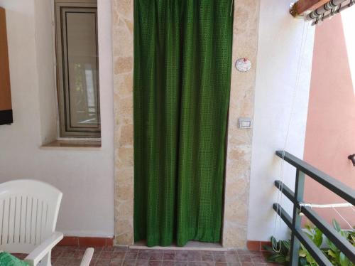 a green curtain on a wall next to a window at Casa Vacanze Mimose in Palinuro
