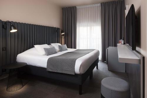 une chambre d'hôtel avec un lit et une télévision dans l'établissement Hôtel Diana Dauphine, à Strasbourg