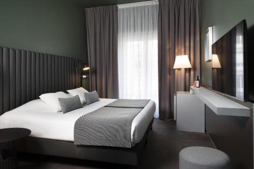 a hotel room with a bed and a sink at Hôtel Diana Dauphine in Strasbourg