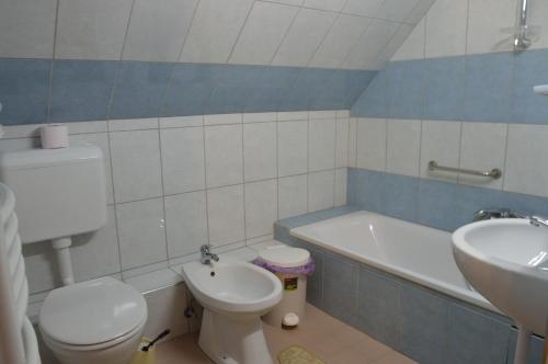a bathroom with a toilet and a sink and a tub at Kisherceg Szálláshely in Budapest