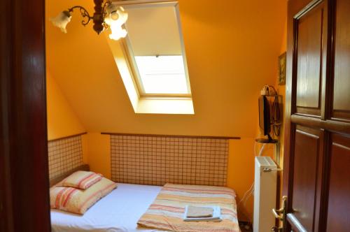 a bedroom with a bed with a mirror and a window at Kisherceg Szálláshely in Budapest